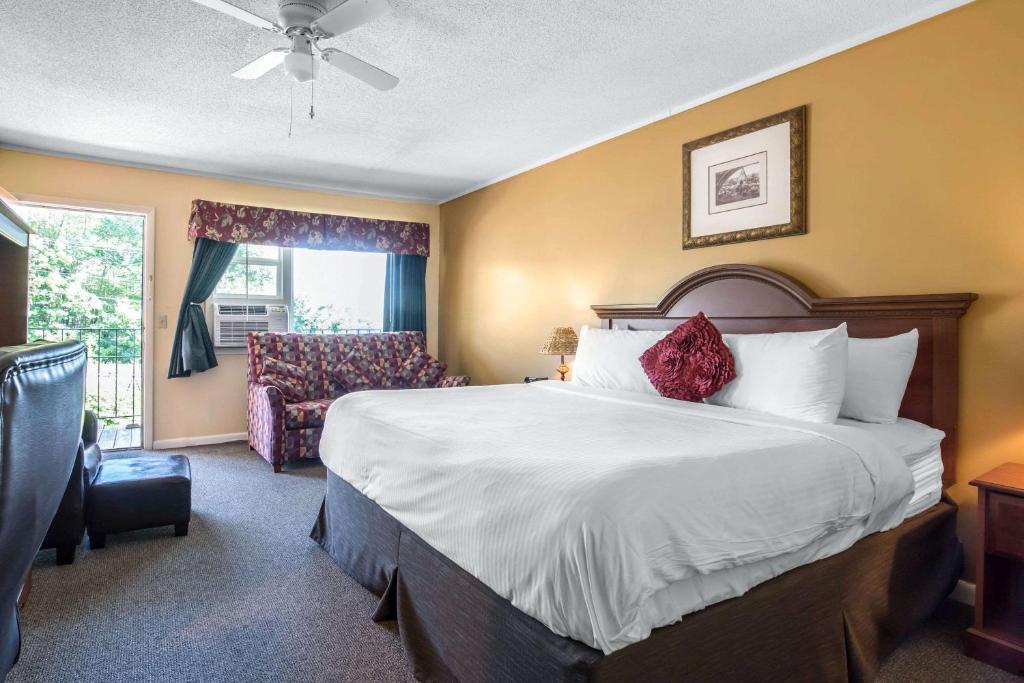 a hotel room with a bed and a chair at Econo Lodge Inn & Suites in Tilton