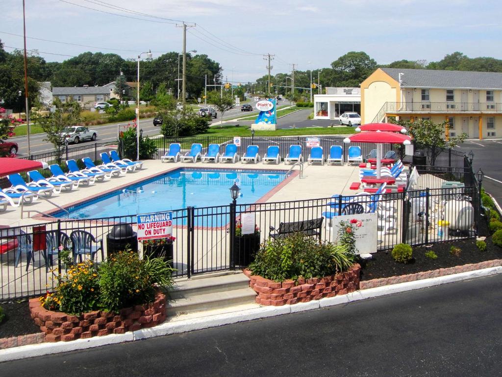 a swimming pool with chairs and a resort at Econo Lodge in Somers Point