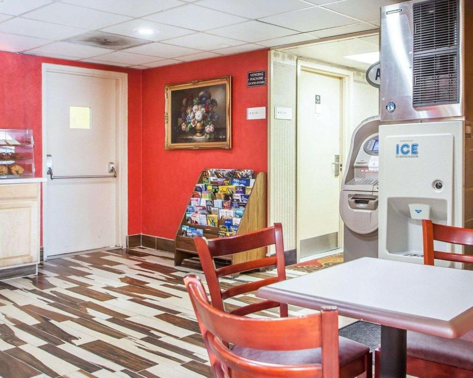 a dining room with a table and chairs and red walls at Days Inn by Wyndham Jersey City in Jersey City