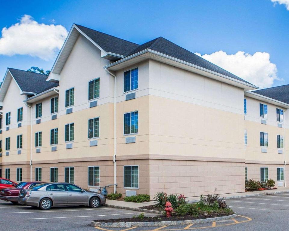 un gran edificio con coches estacionados en un estacionamiento en Tapa Hotel, Inn & Suites, en Mahwah