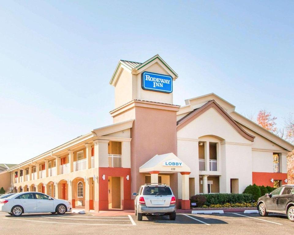 a hotel with cars parked in a parking lot at Rodeway Inn Mount Laurel Hwy 73 in Mount Laurel