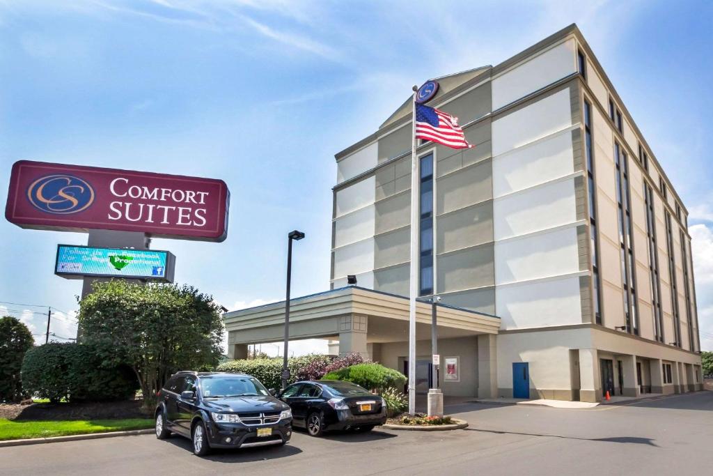 a hotel with an american flag in front of a building at Comfort Suites at Woodbridge in Avenel
