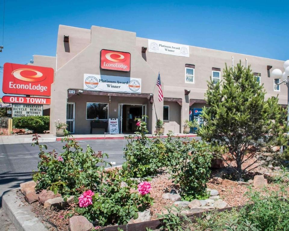 a front view of a building with flowers in front at Econo Lodge Old Town in Albuquerque
