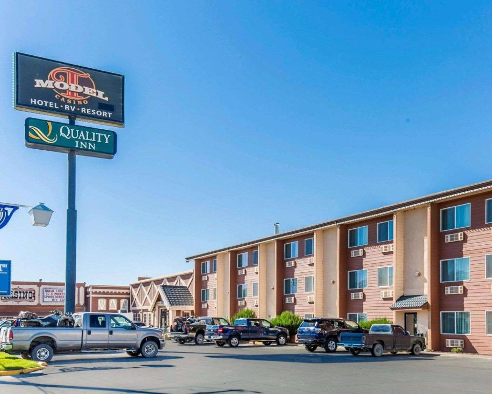 a sign for a hotel with cars parked in a parking lot at Quality Inn Winnemucca- Model T Casino in Winnemucca