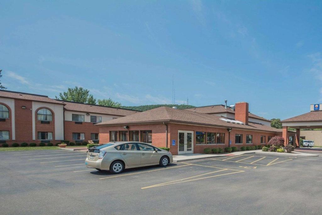 a car parked in a parking lot in front of a building at Quality Inn in Corning