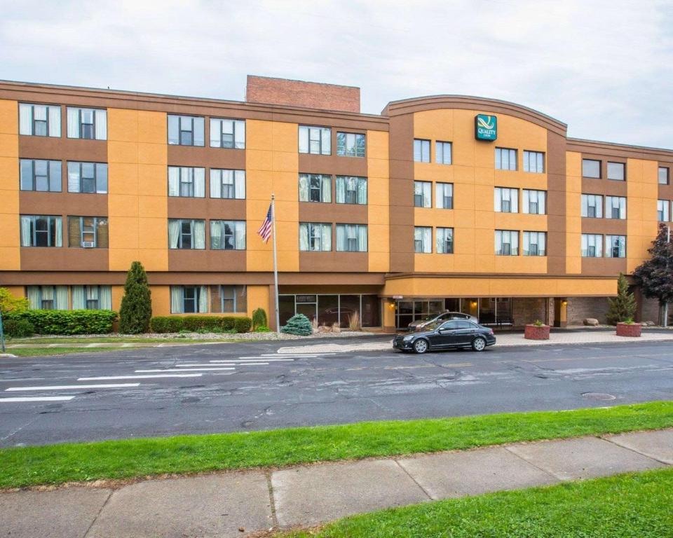 a building with a car parked in front of it at Quality Inn Massena in Massena