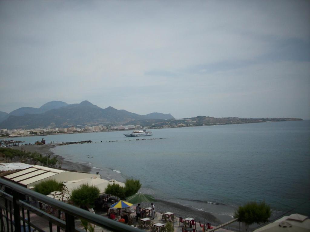 a large body of water with a boat in it at By Captains Studio in Ierápetra