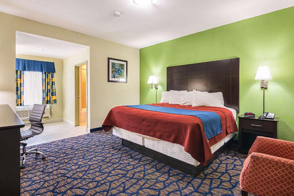 a hotel room with a bed and green walls at Rodeway Inn and Suites Ithaca in Ithaca
