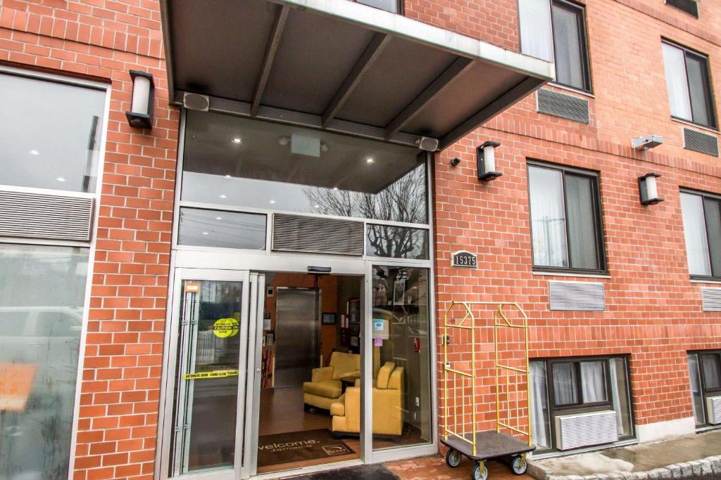 an extension to a brick building with a glass door at Sleep Inn JFK Airport Rockaway Blvd in Queens