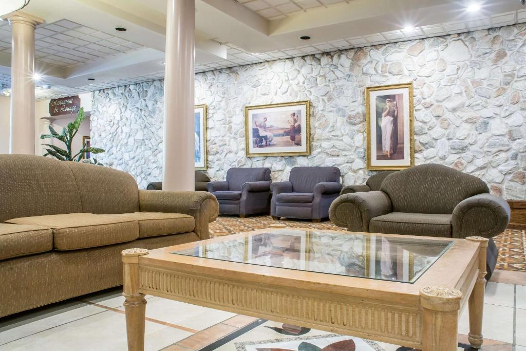a waiting room with couches and a stone wall at Quality Inn & Suites Palm Island Indoor Waterpark in Batavia