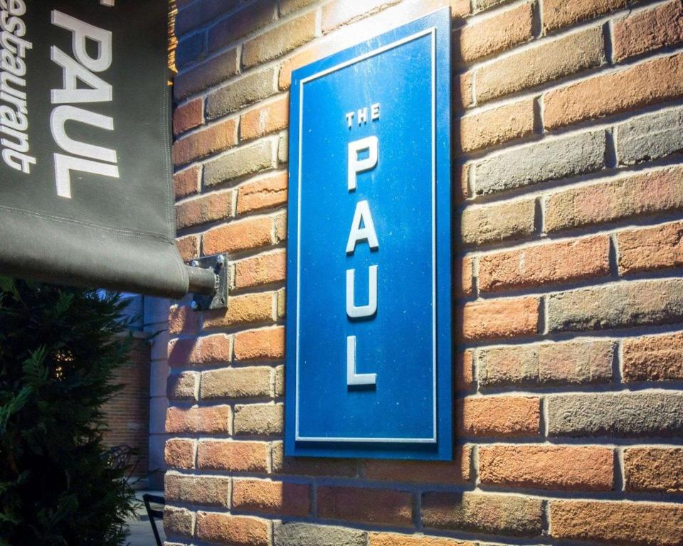a blue and white sign on a brick wall at The Paul Hotel NYC-Chelsea, Ascend Hotel Collection in New York