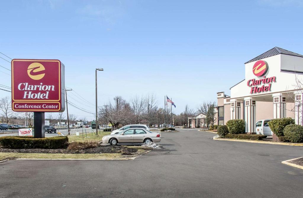 un coche aparcado en un estacionamiento frente a un concesionario de coches en Clarion Hotel and Conference Center en Ronkonkoma