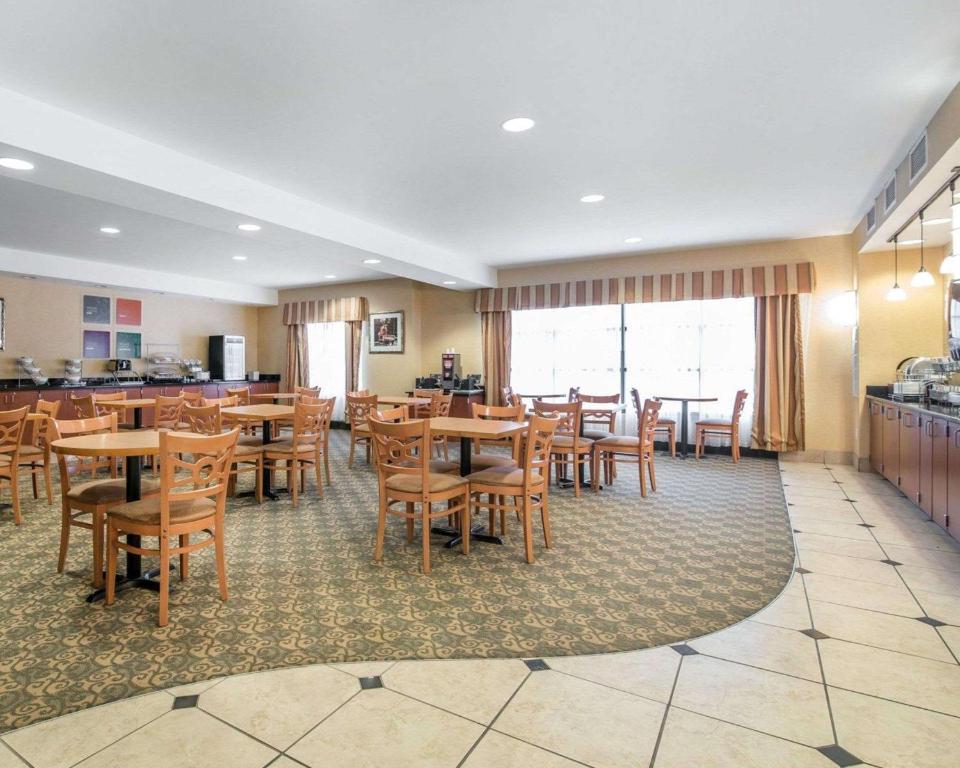 a dining room with wooden tables and chairs at University Inn Vestal in Vestal