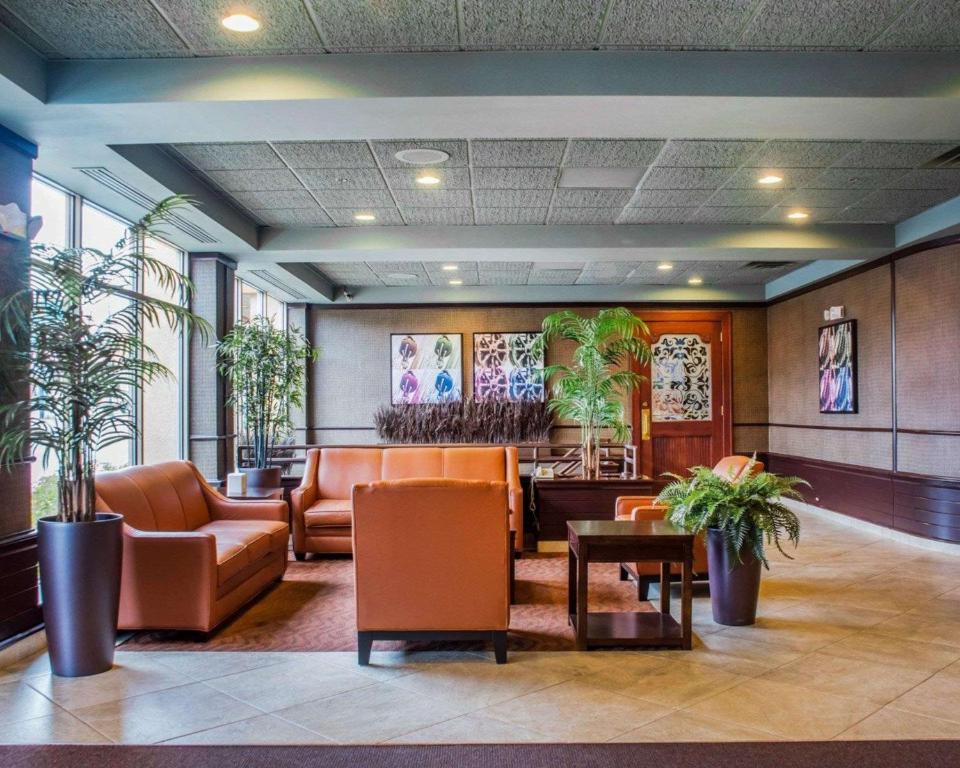 un vestíbulo con muebles y plantas en un edificio en Clarion Hotel & Suites Riverfront Oswego, en Oswego