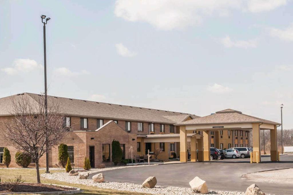 a large brick building with a parking lot at Quality Inn in Defiance