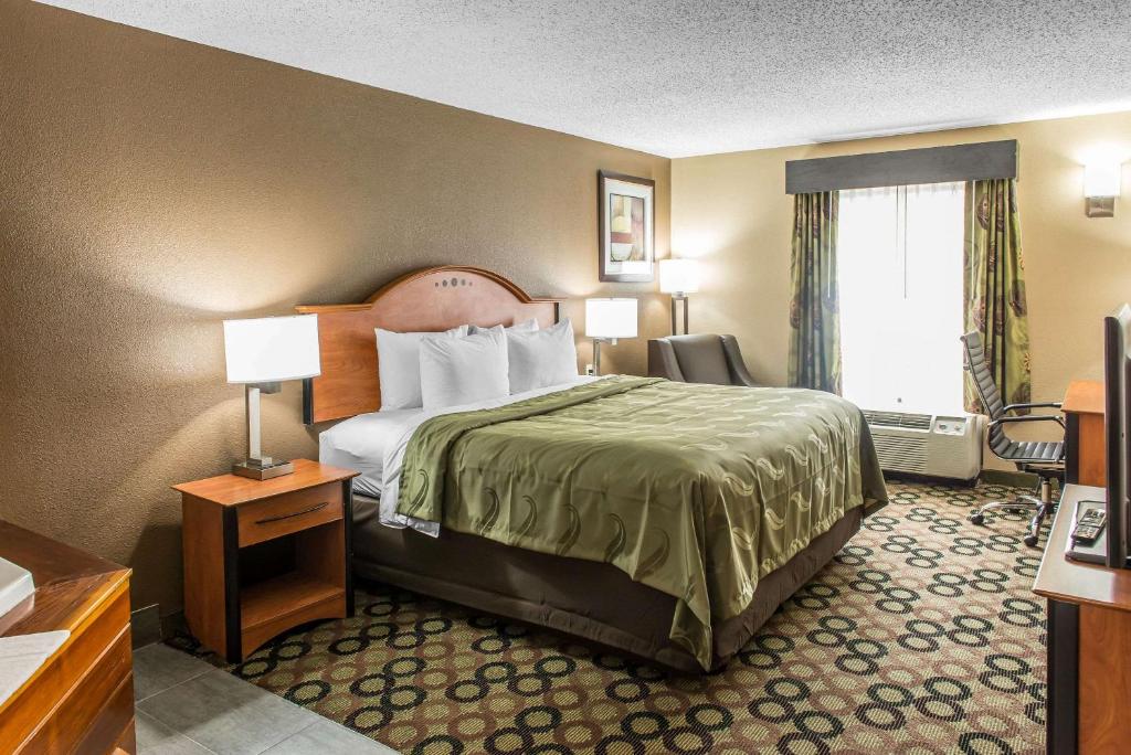 a hotel room with a bed and a window at Quality Inn & Suites Columbus in Columbus
