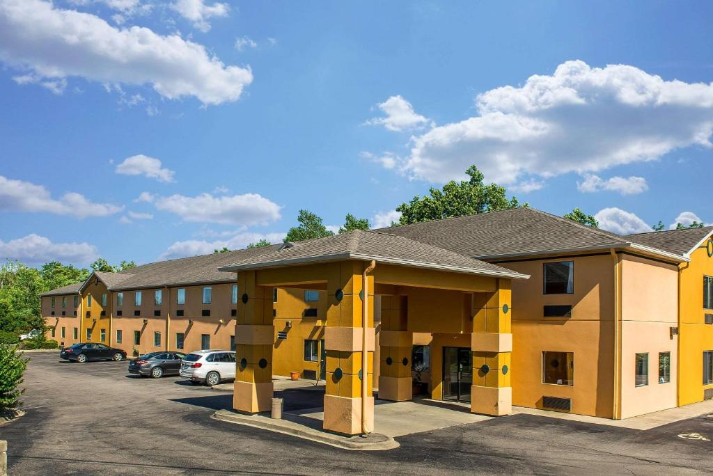 a large yellow building with cars parked in a parking lot at Suburban Studios Mason Hwy 42 in Mason