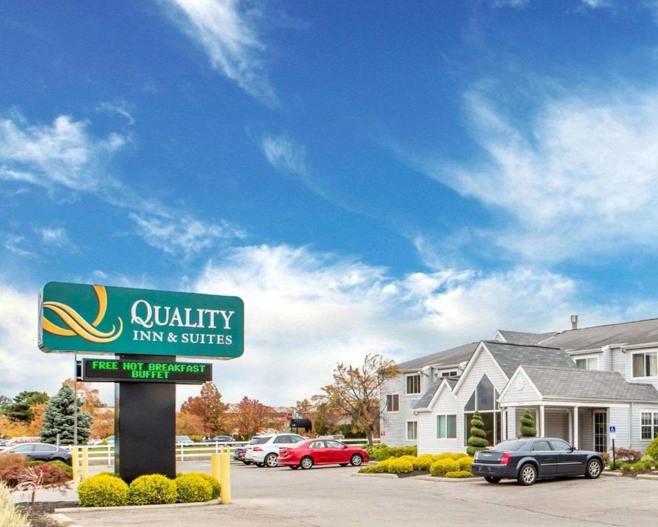 a sign for a hotel with cars parked in a parking lot at Quality Inn & Suites North-Polaris in Worthington