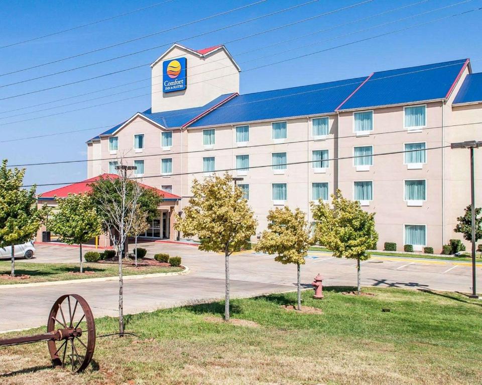 um hotel com uma placa na frente de um edifício em Comfort Inn & Suites em Elk City