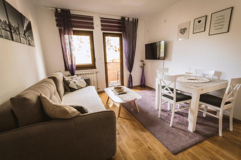 - un salon avec un canapé et une table dans l'établissement Apartmani F&A, à Zlatibor