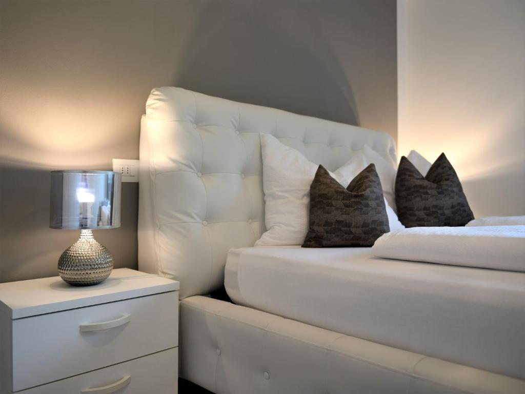um quarto com uma cama com uma cabeceira branca e almofadas em Appartamento Dolomiti em Selva di Val Gardena