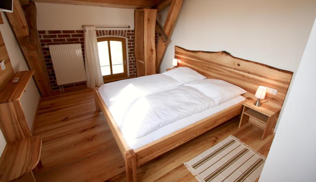 Neuburg-SteinhausenにあるGästehaus Landgut Lischowのベッドルーム1室(大型ベッド1台、木製ヘッドボード付)
