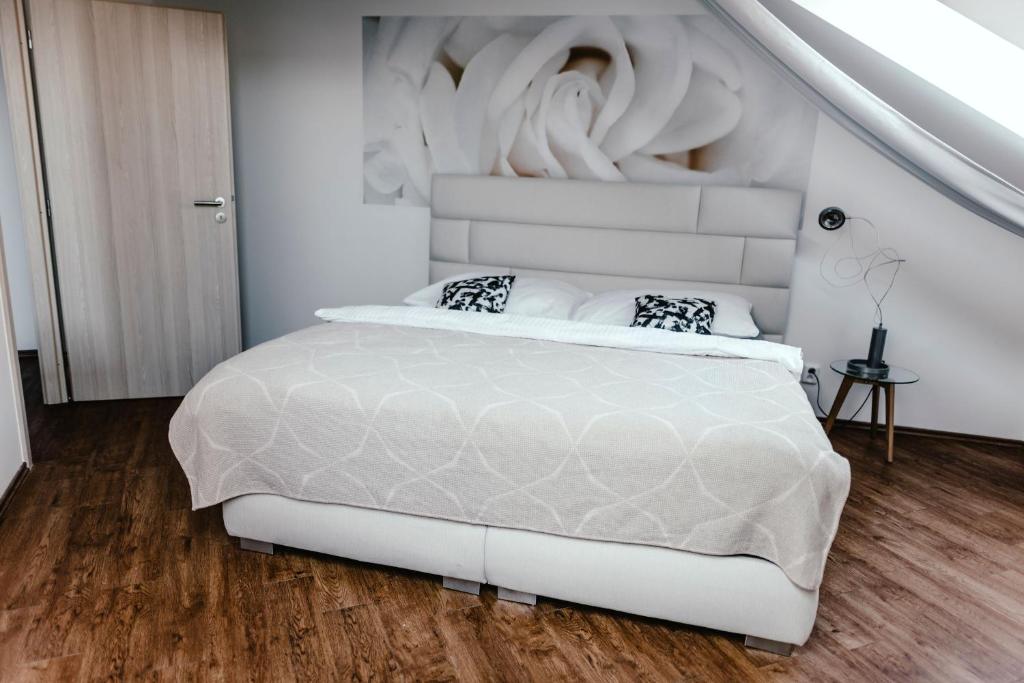 sypialnia z białym łóżkiem z rzeźbą na ścianie w obiekcie Zelný trh 42 w mieście Brno