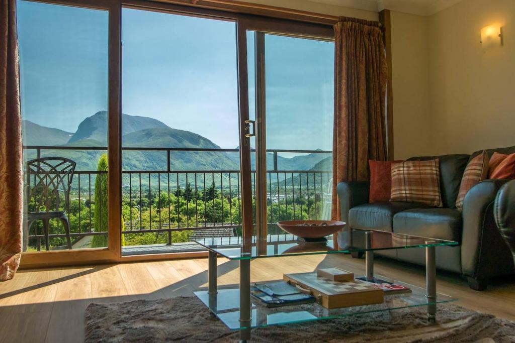 フォート・ウィリアムにあるHighland Self Catering Retreat With Stunning Viewsのリビングルーム(ソファ、大きな窓付)