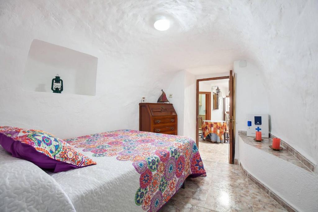 um quarto com uma cama e uma cómoda em Casa Cueva Calatrava em Tabernas