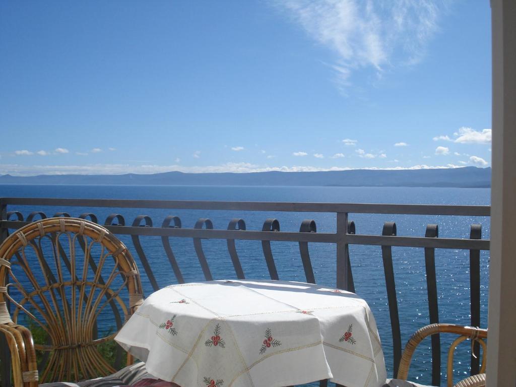 una mesa y sillas en un balcón con vistas al agua en Apartments Santo, en Bol