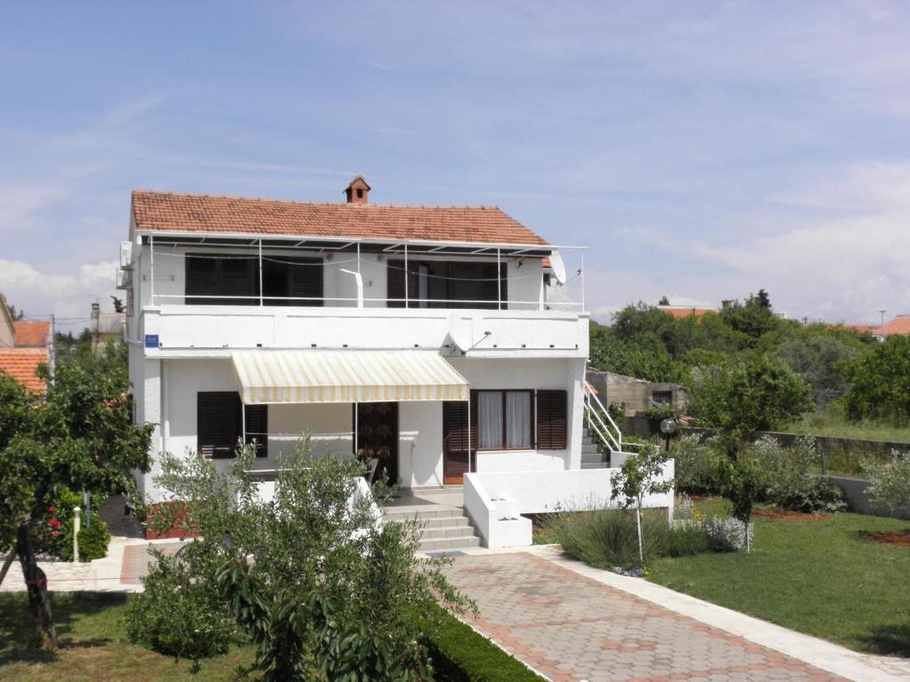een wit huis met een dak bij Apartments Kuce - 150m from the beach with parking in Sušica