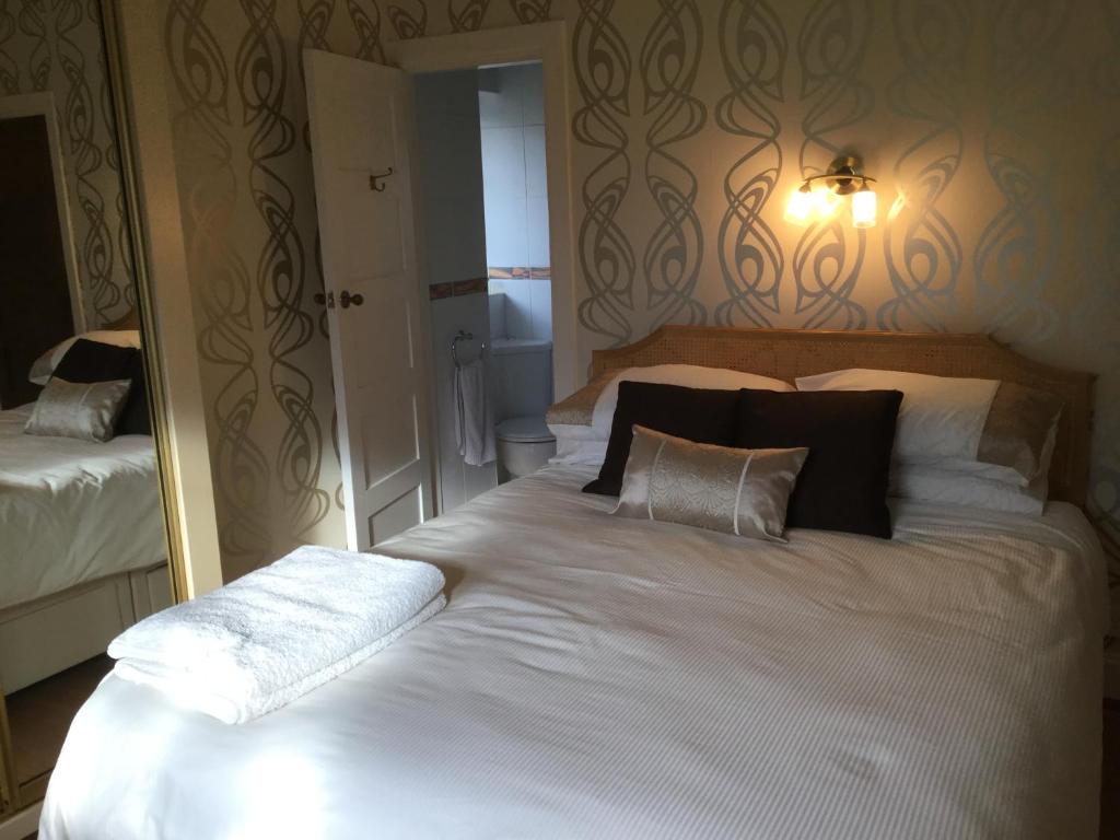 - une chambre avec un grand lit blanc et des oreillers dans l'établissement Maggi’s Home from Home, à Sheffield