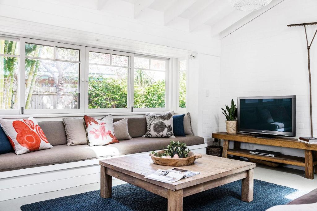 a living room with a couch and a tv at A PERFECT STAY - Beachwood in Byron Bay