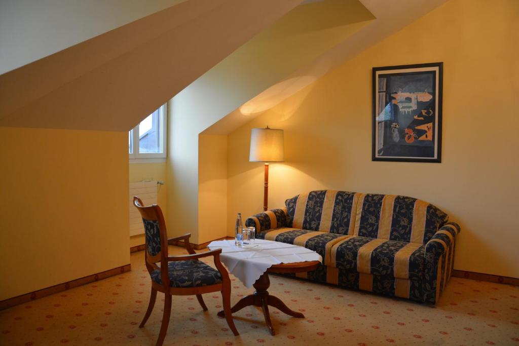 a living room with a couch and a table and a chair at Hotel Federale in Lugano
