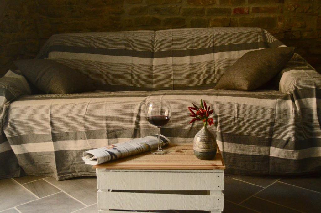 a bed with a table with a glass of wine on it at Langa 4 Love in Novello