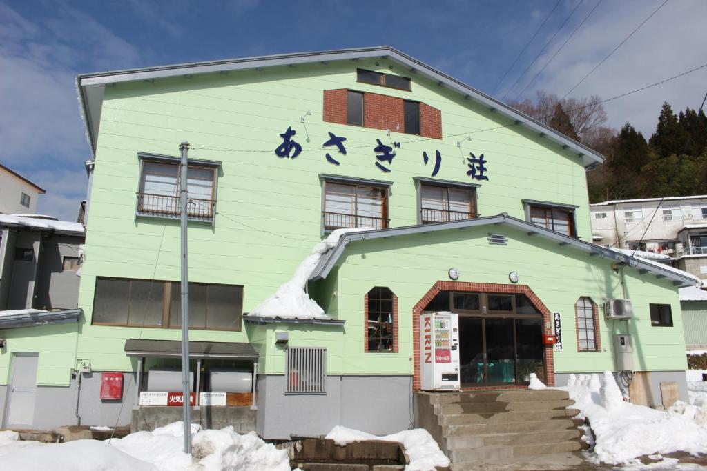 a green building with birds on the side of it at Hachikogen Furusato Asagiriso in Yabu