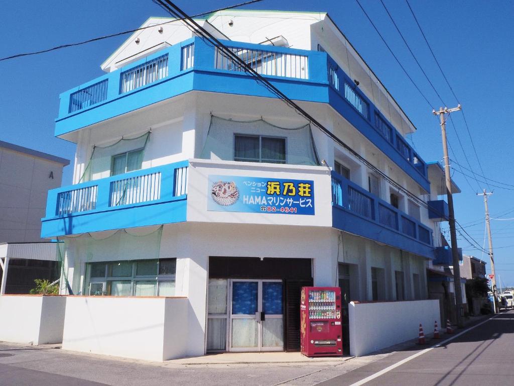 un edificio azul y blanco con un cartel en él en Pension New Hamanoso, en Ishigaki Island
