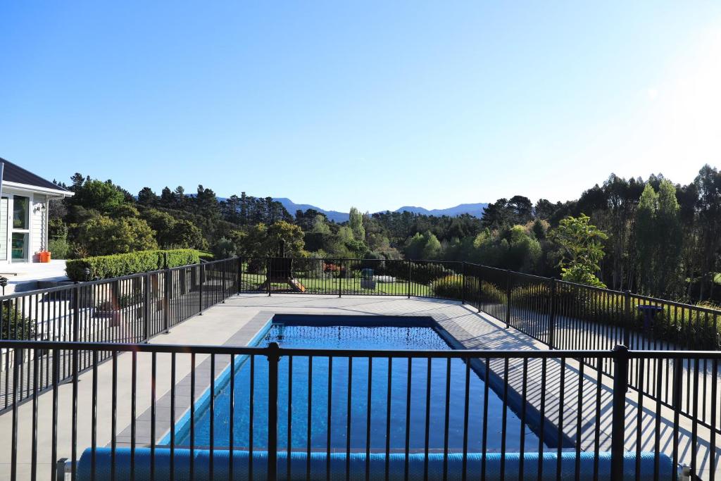 a swimming pool on a balcony with a fence at Villa93 in Katikati