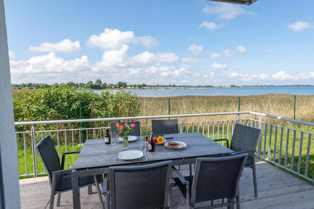 a table on a deck with a view of the water at To Huus in Olpenitz