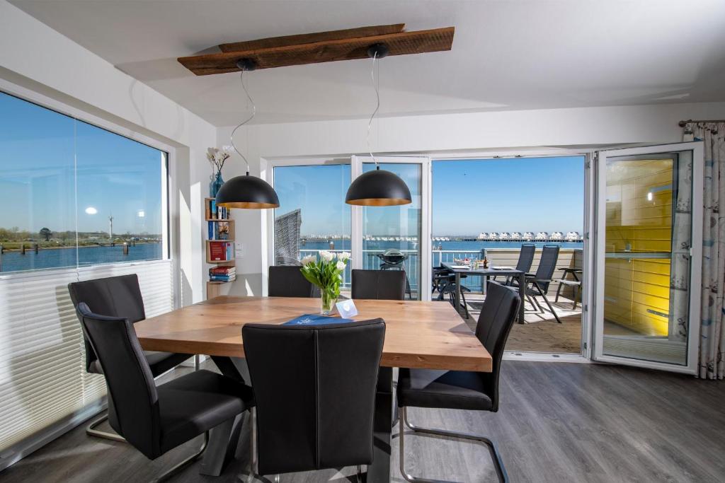 een eetkamer met een houten tafel en stoelen bij Hus Twustern in Olpenitz