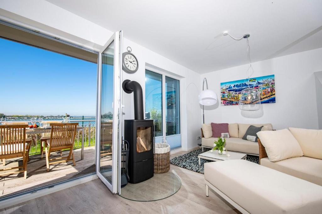 a living room with a fireplace and a view of the ocean at Villa Kunterbunt in Olpenitz