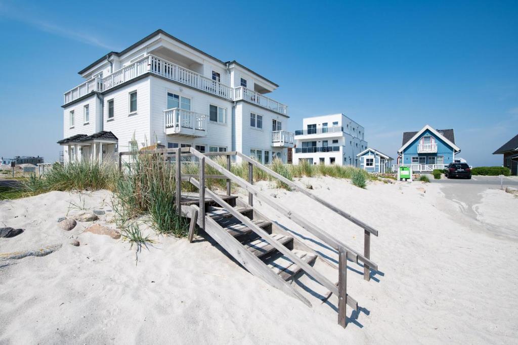 a house on the beach with a wooden ramp to the sand at Marina View in Olpenitz