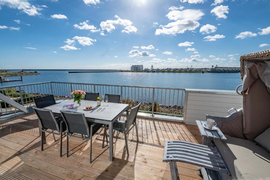 a table and chairs on a deck with a view of the water at BlueLounge in Olpenitz