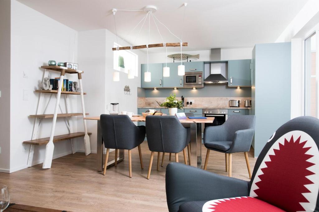 a kitchen and dining room with a table and chairs at Fischermanns Freund in Olpenitz