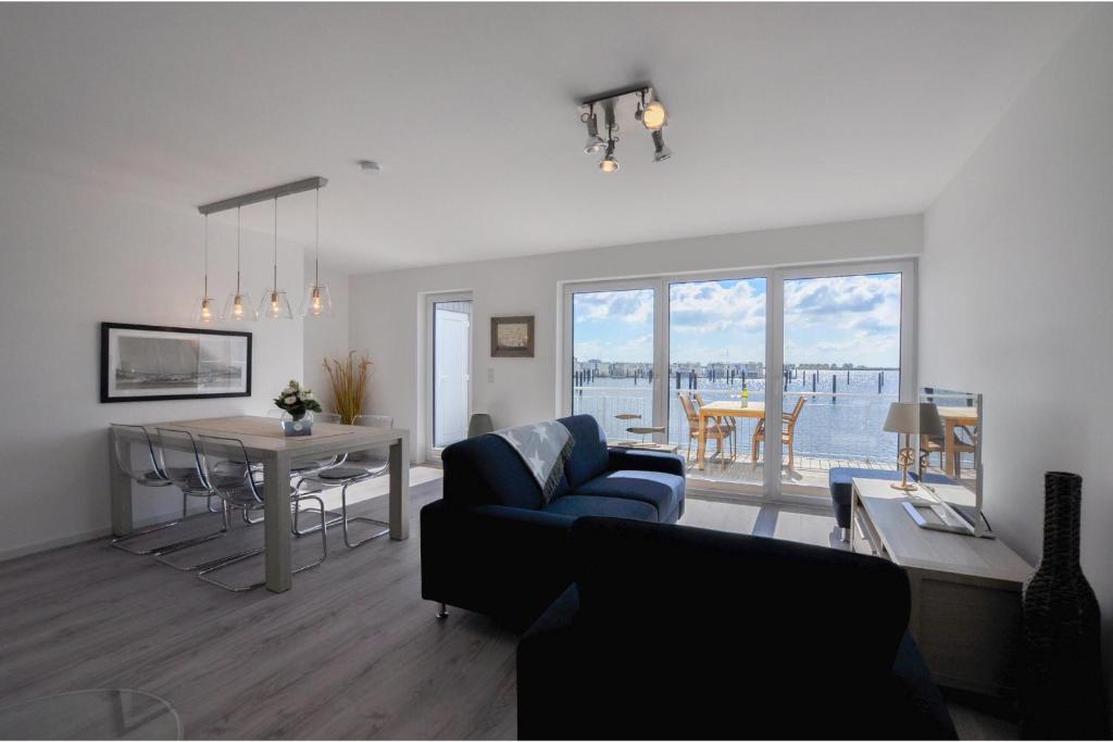 a living room with a blue couch and a table at Nantucket in Olpenitz