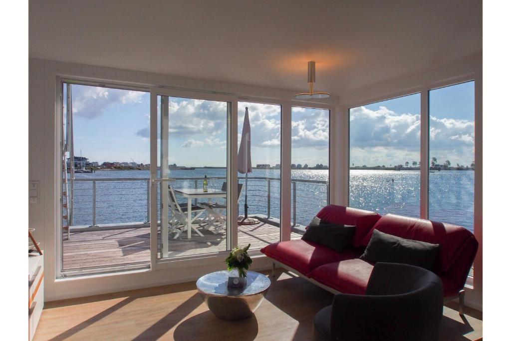 ein Wohnzimmer mit einem Sofa und Blick auf das Wasser in der Unterkunft Schwimmendes Haus Art Emotion in Olpenitz