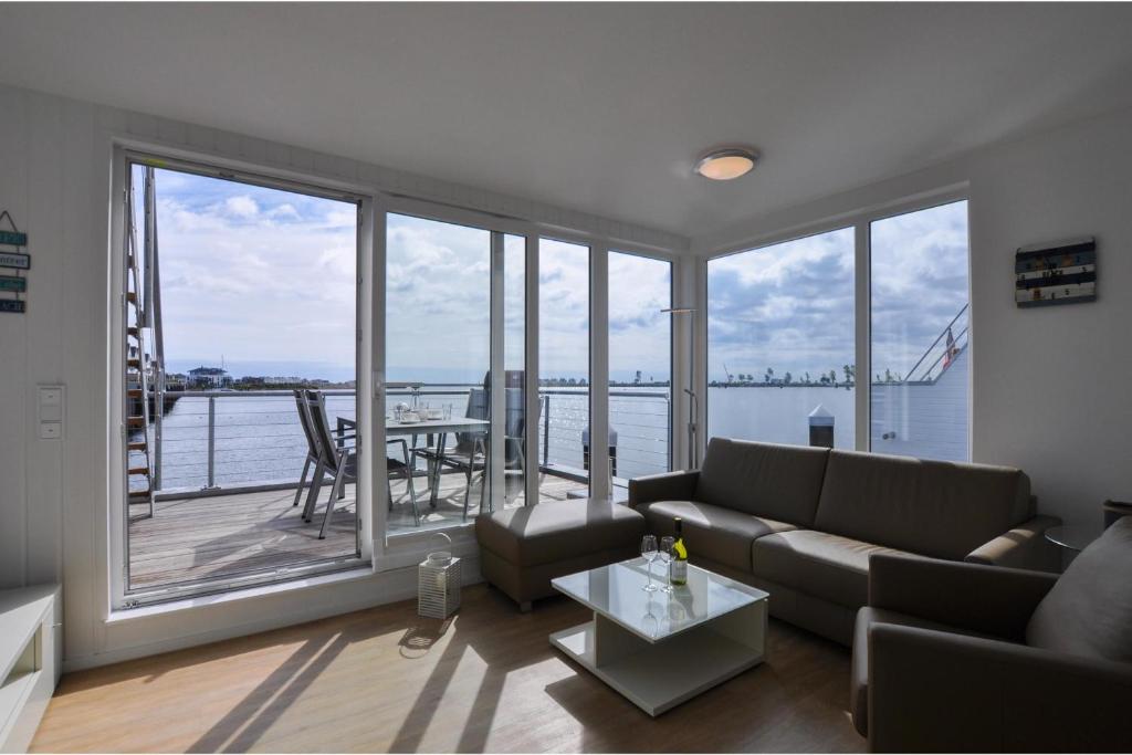 a living room with a couch and a large window at Schwimmendes Haus Hausboot in Olpenitz