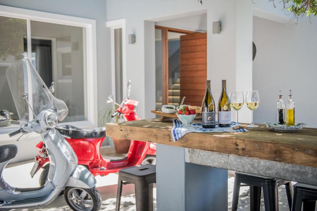 a motor scooter parked next to a table with wine glasses at The Whale on Main B&B in Hermanus