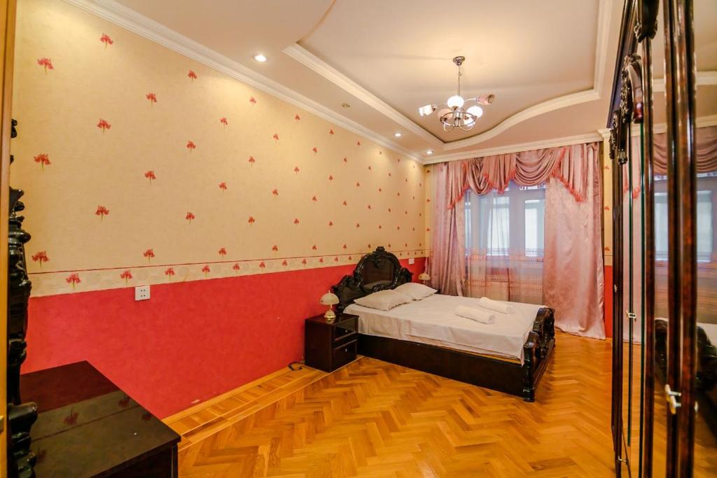 een slaapkamer met een bed en een rode muur bij Mirza Fatali Akhundova 154 Apartment in Baku