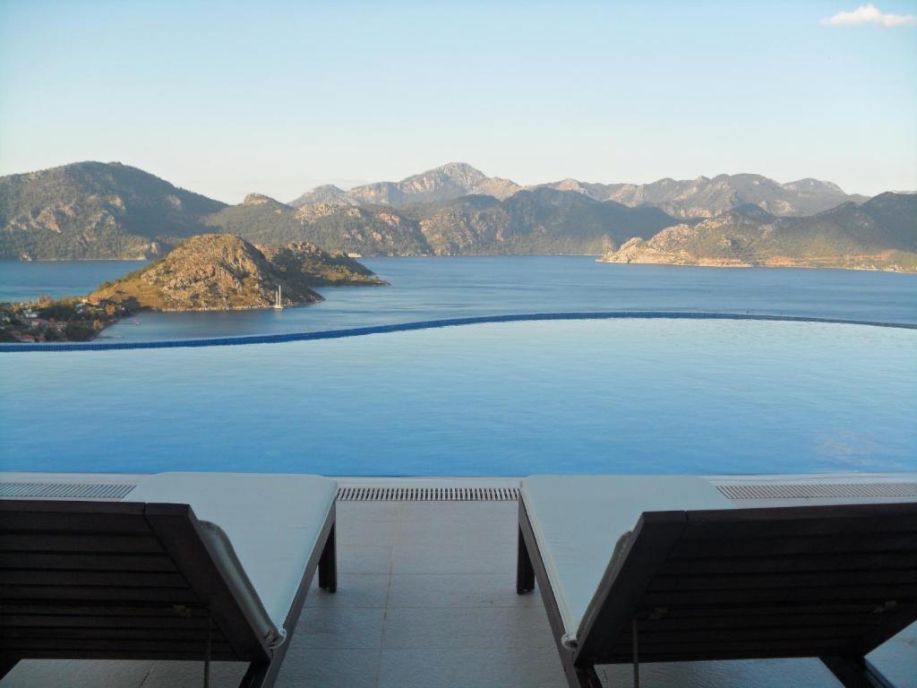 une vue sur une grande étendue d'eau avec deux bancs dans l'établissement Loca Hotel, à Selimiye